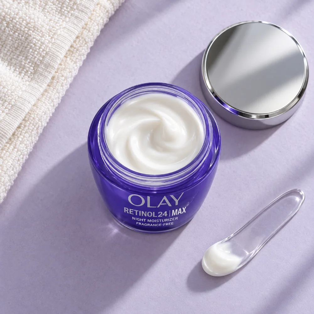 نمای بالای کرم شب اولای Retinol 24 MAX در ظرف باز کنار درِ نقره‌ای و کاردک